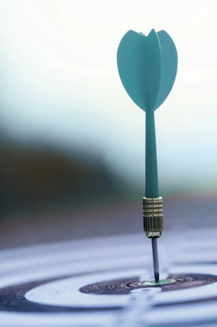Photograph of a dart in the centre of a dartboard.